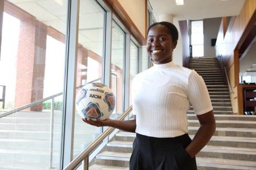 Student poses with soccer ball